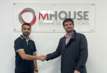 Faisal Sattar, chief exec at MHouse, and Tom Walker, Volumatic's Scotland Account manager. shake hands in front of the MHouse logo.