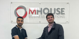 Faisal Sattar, chief exec at MHouse, and Tom Walker, Volumatic's Scotland Account manager. shake hands in front of the MHouse logo.