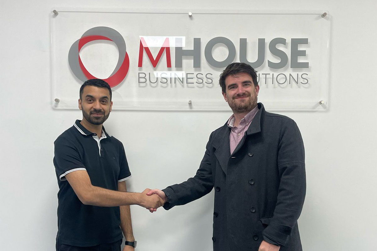 Faisal Sattar, chief exec at MHouse, and Tom Walker, Volumatic's Scotland Account manager. shake hands in front of the MHouse logo.