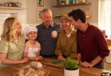 A family gather round a kitchen table together looking happy, still image taken from OXO TV advert.