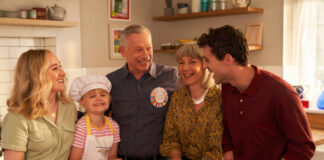 A family gather round a kitchen table together looking happy, still image taken from OXO TV advert.