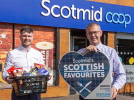 Scotmid Scottish Favourites returns Two people stand outside a Scotmid store, one person holds a sign for the Scotmid Scottish Favourites Competition while the other holds a basket filled with Scottish produce.