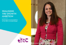 Front cover of SRC's Realising the Growth Ambition: Retail industry recommendations for the 2025-26 Scottish Budget with an aimge of Kate Forbes standing in Scottish Parliament.