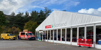 Image of the front of the Spar Scotland trade show tent with vans parked outside.