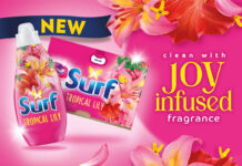 Promotional image of the Surf laundry detergent rebrand, with pack shots of the products against a pink background that has flowers. The text reads 'clean with joy infused fragrance'.