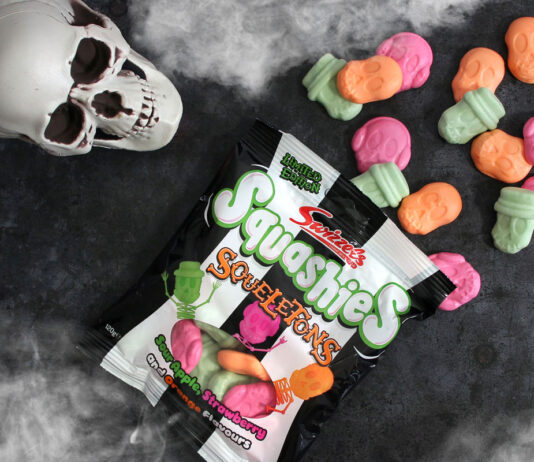 Swizzels brings the Squeals this Halloween A packet of Swizzels Squashies Squeletons lie on a table with the sweets spilled out, above the packet is a skull and fog at the top and bottom of the image.