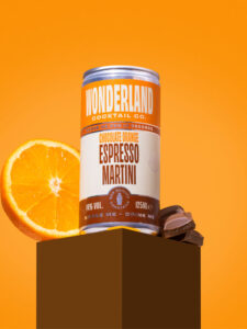 Lifestyle image of Wonderland Cocktails Chocolate Orange Espresso Martini can with a slice of orange and pieces of chocolate behind the can.