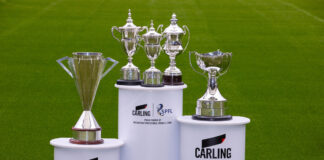 Scottish Premier Football League trophies on stands on a football pitch with Carling branding on the stands.