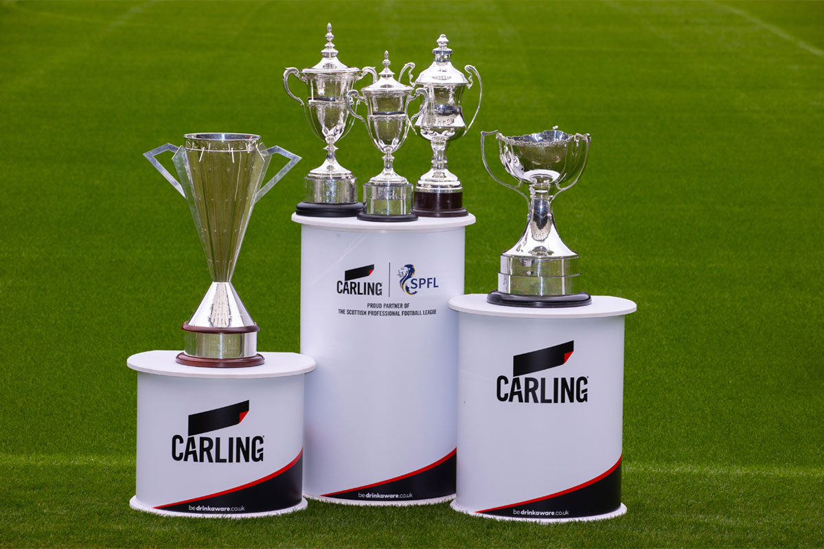 Scottish Premier Football League trophies on stands on a football pitch with Carling branding on the stands.