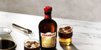 A bottle of Drambuie with two Drambuie Iced Espresso serves stand next to the bottle on a countertop.