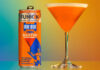 Life style image of a Funkin Cocktails Irn-Bru Vodka Martini can with the drink served in a martini glass next to it.