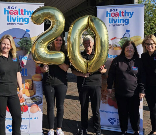 Healthy Living Programme marks 20 years The SGF Healthy Living Programme team stand holding a two balloon and a zero balloon together in front of HLP branded stands.
