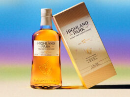 A bottle of the new look for Highland Park stands next to the new packaging design for the box with a colour gradient background.