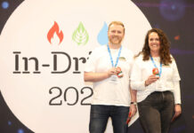 L-R Joe Harris, Lonkero and Paige Gibbons, Lonkero both stand in front of the In-Drinks logo holding cans of Lonkero.