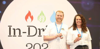 L-R Joe Harris, Lonkero and Paige Gibbons, Lonkero both stand in front of the In-Drinks logo holding cans of Lonkero.