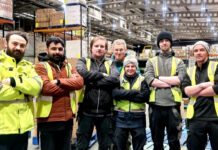 Staff members at Mark Murphy Dole in Edinburgh stand in the warehouse folding their arms.