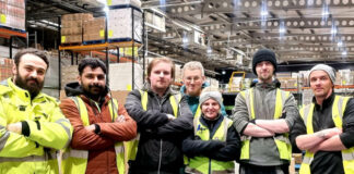 Staff members at Mark Murphy Dole in Edinburgh stand in the warehouse folding their arms.