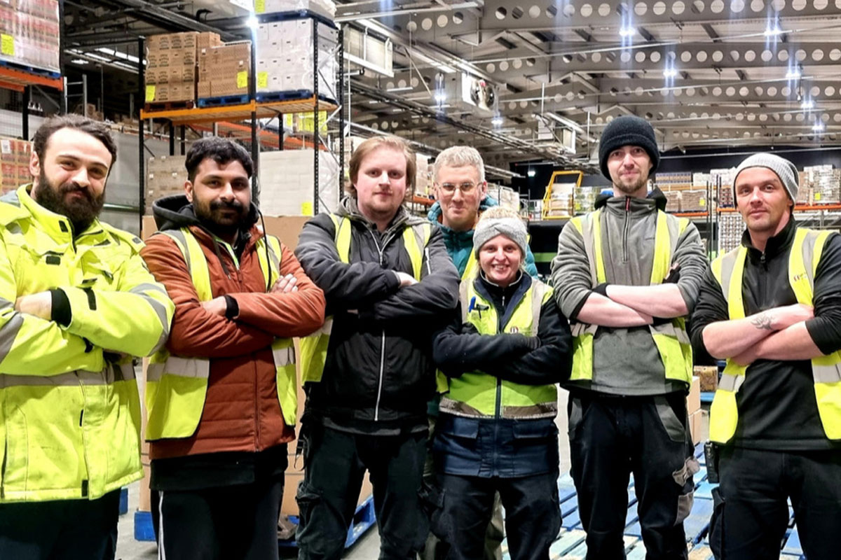 Staff members at Mark Murphy Dole in Edinburgh stand in the warehouse folding their arms.