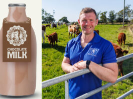 Bryce Cunningham, founder of Mossgiel Farm, stands in a field with cows behind him with a pack shot of a Mossgiel Dairy Farm Chocolate Milk bottle.