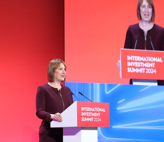 ACS warns of £634m cost from Budget Rachel Reeves, chancellor of the exchequer, stands at a podium delivering a speech with a TV screen featuring her to her left.