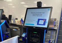 A Scotmid Co-op self-service checkout machine with a notice informing customers about CCTV in operation.