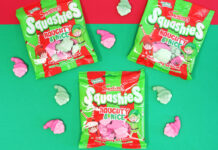 Packets of Swizzels Squashies Naughty & Nice sit against a red and green backdrop with the sweets scattered across the table.