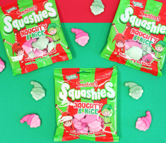 Swizzels rolls out Christmas Squashies Packets of Swizzels Squashies Naughty & Nice sit against a red and green backdrop with the sweets scattered across the table.