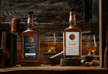 Bottles of Stanhope Kentucky Whiskey Bourbon and Rye Whiskey stands on a wooden table with nosing glasses containing the whiskies.