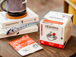 Ueshima Coffee Company Pour Over Coffee Bags box with a sachet of the coffee bag next to it with a pile of books on a wooden table.