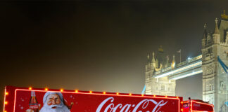 The Coca-Cola Christmas Truck for 2024 season is in front of Tower Bridge during the night.