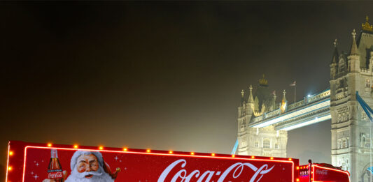 The Coca-Cola Christmas Truck for 2024 season is in front of Tower Bridge during the night.