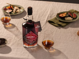 Eden Mill launches rare PX cask bottling A bottle with Eden Mill Pedro Ximénez Single Cask sits on a table with food on plates and a nosing glass with a sample of the whisky inside.
