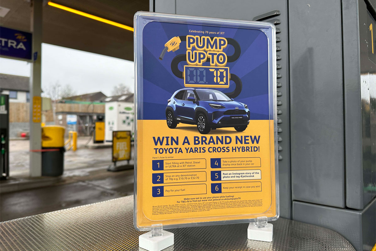 A Jet forecourt garage with a POS highlighting a prize giveaway to win a new car.