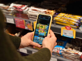 Jisp trials in-store NPD service A person holds a phone with Jisp app open on it to scan a product on a store shelf.