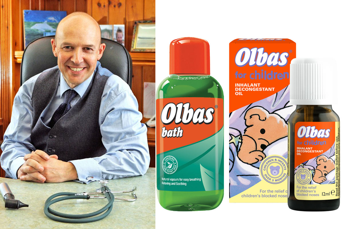 Dr Roger Henderson, GP and spokesperson for Olbas, sits at a table with pack shots of Olbas Bath and Olbas For Children Inhalant Decongestant Oil.