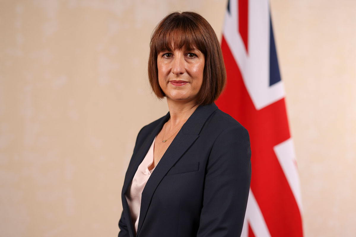 Chancellor of the exchequer Rachel Reeves stands in front of a Union Jack flag.