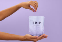 A person holds a bag of TRIP Magnesium Gummies and takes a few out with their other hand against a lilac purple background.