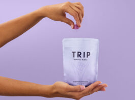 A person holds a bag of TRIP Magnesium Gummies and takes a few out with their other hand against a lilac purple background.