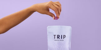 A person holds a bag of TRIP Magnesium Gummies and takes a few out with their other hand against a lilac purple background.