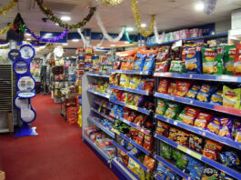 Inflation rises for second month in a row A shop floor with crisps on the shelves to the right and tinsel hanging from the roof.