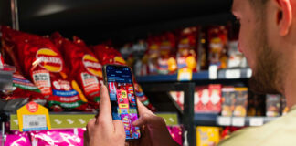 A person uses the Jisp Scan & Save feature on his phone to scan products in a store.