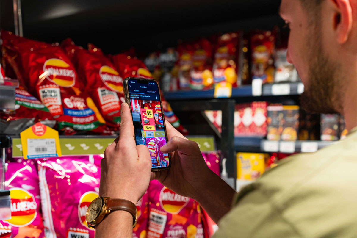 A person uses the Jisp Scan & Save feature on his phone to scan products in a store.