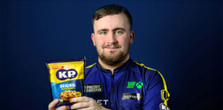 Darts star Luke Littler holds a pack of KP Nuts Original Salted Peanuts.