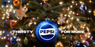 A Christmas tree with a blue bauble hanging from its branch with the Pepsi logo on it and surrounding text that reads "Thirsty For More".