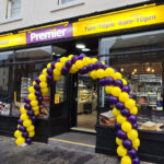 Premier opens up in Dunbar Front entrance to Premier Dunbar with a balloon arch outside the front door made with yellow and purple balloons.