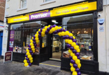 Front entrance to Premier Dunbar with a balloon arch outside the front door made with yellow and purple balloons.