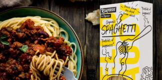 A packet of Realfoods by Oraganico Organic Spaghetti is placed on top of an image of a bowl of spaghetti bolognese.