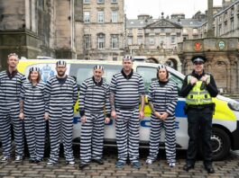 Scotmid ‘Jail birds’ raise £15k for charity Team members from Scotmid dressed up in prisoner outfits as part of a charity fundraising efforts in front of a police van with an officer next to them.