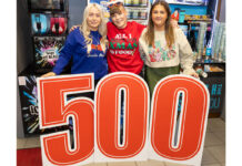 Staff members from Ardgowan Hospice and Spar Greenock stand behind a large 500 sign in the Spar Greenock store.