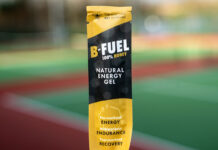 A packet of Scottish Bee B-Gel is held up against a blurred out field in the background.